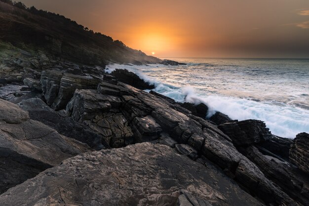 Sonnenuntergang an der baskischen Küste unter dem Berg Jaizkibel in Hondarribia, Baskenland.