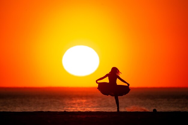 Foto sonnenuntergang auf dem strand mit der tänzerin salome oliveira