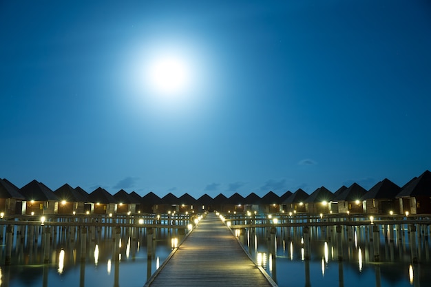Sonnenuntergang auf der Insel Malediven, luxuriöses Wasservillenresort und hölzerner Pier.