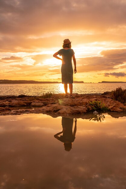 Sonnenuntergang auf Ibiza im Urlaub eine junge Frau am Meer in San Antonio Abad Balearen