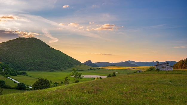 Sonnenuntergang dramatischer himmel über dem hochland von montelago marken italien einzigartige grüne hügel- und berglandschaft