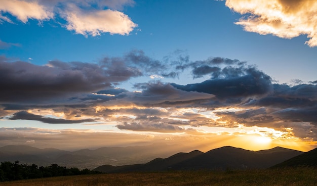 Sonnenuntergang dramatischer Himmel über Fabriano Stadt Marken Italien Sonnenstrahlen zwischen Wolken über einzigartigen Hügeln und Bergen Landschaft emotionales Gefühlskonzept