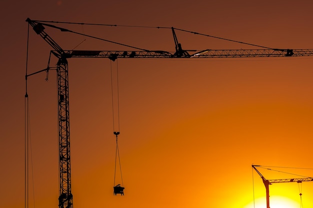 Sonnenuntergang hinter einem Baustellen-Silhouette-Gebäude mit Kränen