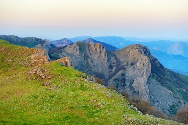 Sonnenuntergang in den Bergen mit Felsen und grünem Gras