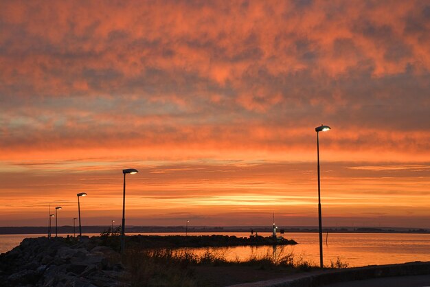 Sonnenuntergang in Schweden am Hafen des Vaettern-Sees Leuchtturm im Hintergrund
