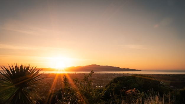 Sonnenuntergang mit buntem Himmel vor Bergkulisse