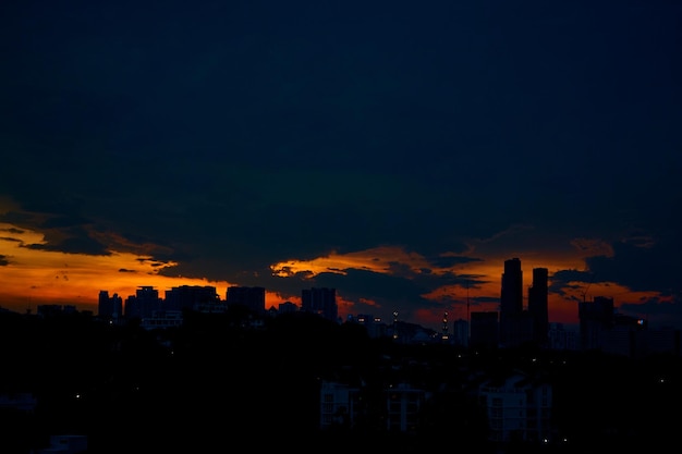 Sonnenuntergang mit dunklen Regenwolken über der modernen Stadt