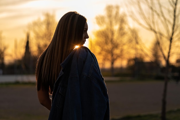 Sonnenuntergang mit einer schönen jungen Frau mit ihrer Jacke über der Schulter