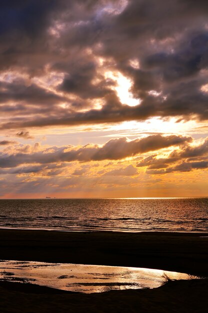 Sonnenuntergang mit Reflexion über den Sand am Strand Saulkrasti, Lettland, Ostsee?