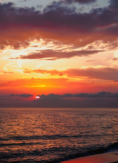 Sonnenuntergang mit Reflexionen im Wasser, Sonnenlicht und farbigen orangefarbenen Wolken
