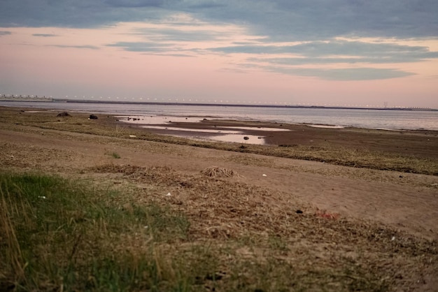 Sonnenuntergang über dem Meer Schöner bewölkter Abendhimmel Staudammbrücke in der Ferne