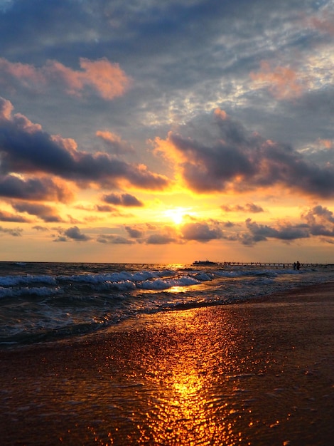 Sonnenuntergang über dem Meer Schöner Sonnenuntergang Schäumende Wellen rollen über das sandige Ufer Vityazevo Anapa Schwarzes Meer Touristenmekka Kurort Bunte Wolken am Abendhimmel Die Strahlen spiegeln sich im Wasser