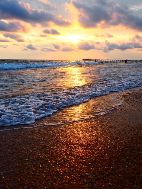 Sonnenuntergang über dem Meer Schöner Sonnenuntergang Schäumende Wellen rollen über das sandige Ufer Vityazevo Anapa Schwarzes Meer Touristenmekka Kurort Bunte Wolken am Abendhimmel Die Strahlen spiegeln sich im Wasser