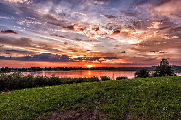 Sonnenuntergang über dem See im Sommer