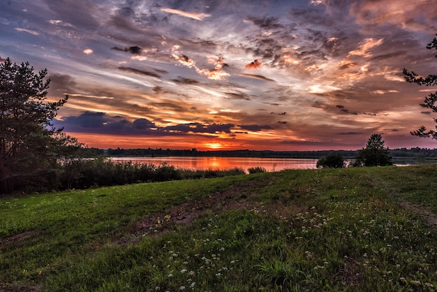 Sonnenuntergang über dem See im Sommer