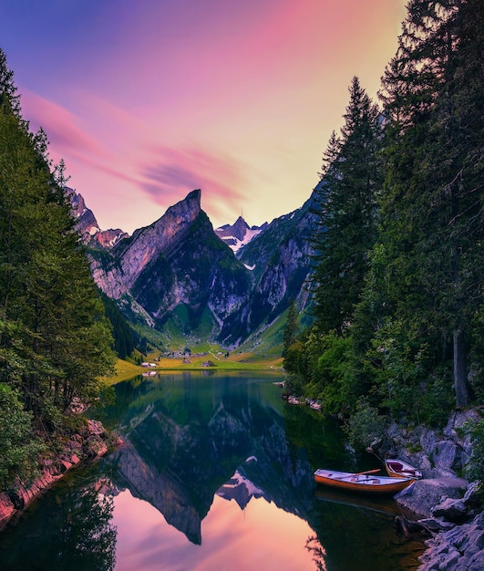 Sonnenuntergang über dem seealpsee mit kleinen booten in den schweizer alpen schweiz