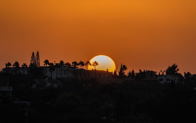 Sonnenuntergang über den Dächern von Häusern in Protaras, Zypern