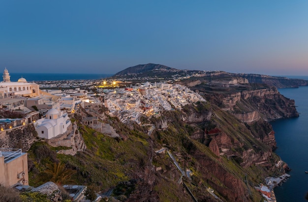 Sonnenuntergang über den Lichtern der Stadt Santorin kommt über Griechenland