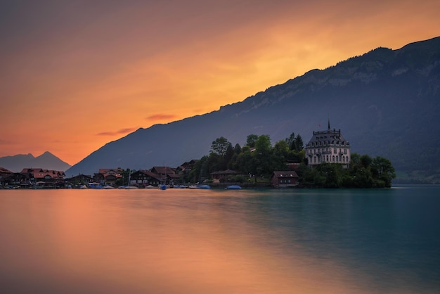 Sonnenuntergang über der halbinsel iseltwald und dem ehemaligen schloss in der schweiz