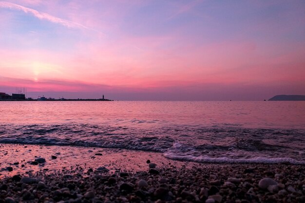 Sonnenuntergang und Leuchtturm am Meer