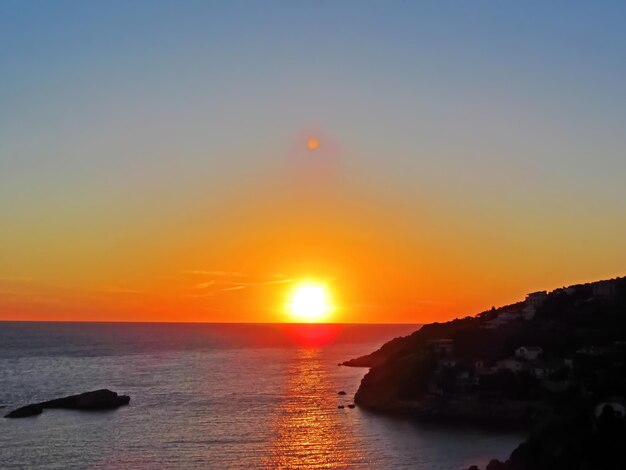 Sonnenuntergang vor dem Hintergrund von Meeresfelsen und Inseln