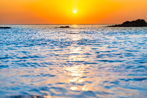 Foto sonnenuntergangmeer mit felsen und abendsonne am dramatischen himmel