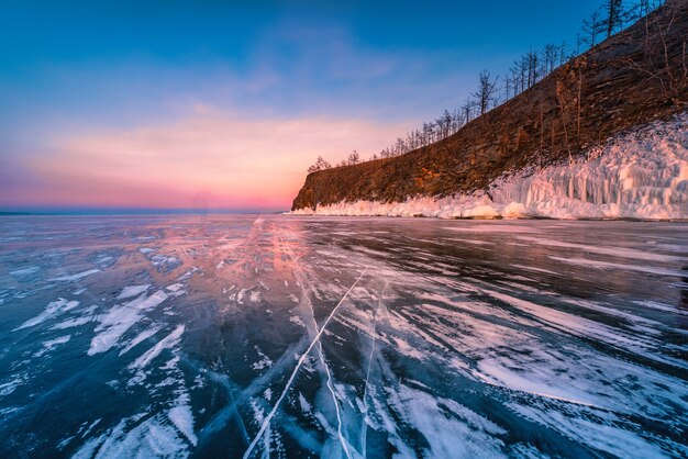 Sonnenuntergangshimmel mit natürlichem brechendem Eis über gefrorenem Wasser am Baikalsee, Sibirien, Russland.