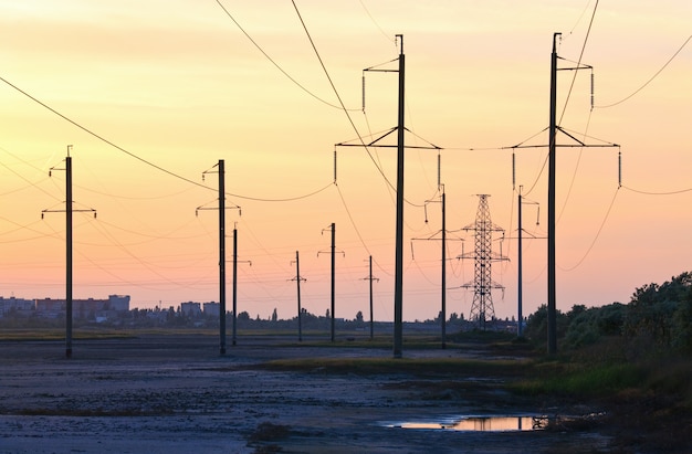 Sonnenuntergangshimmel über der Stadt und Hochspannungsleitung