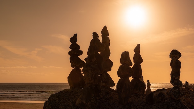 Sonnenuntergangslandschaft am Strand mit Steinhaufen im Vordergrund