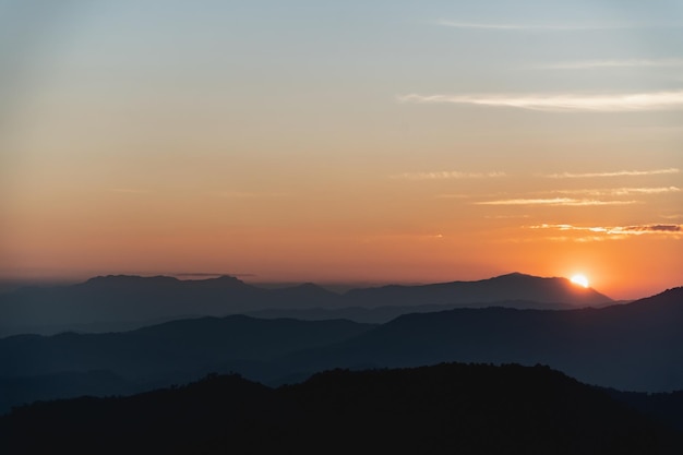 Sonnenuntergangslandschaft mit Berg- und Sonnengoldbeleuchtung unter lebendigem buntem Abendhimmel in den Bergen