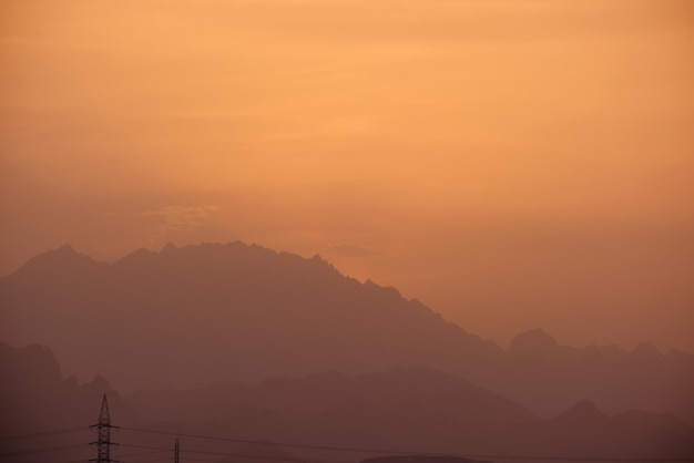 Sonnenuntergangslandschaft mit dunklen Berggipfeln in der ägyptischen Wüste