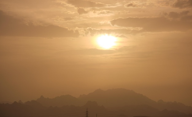 Sonnenuntergangslandschaft mit dunklen Berggipfeln in der ägyptischen Wüste
