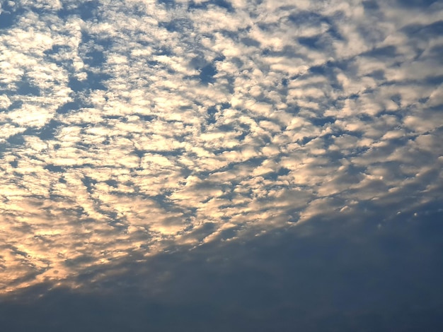 Sonnenuntergangwolken in den Hintergründen des blauen Himmels