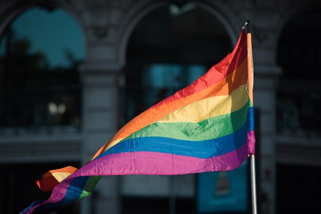 Sonnige Gay-Flagge auf städtischem Hintergrund