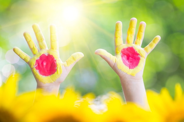 Sonnige Hände gegen grünen Frühlingshintergrund