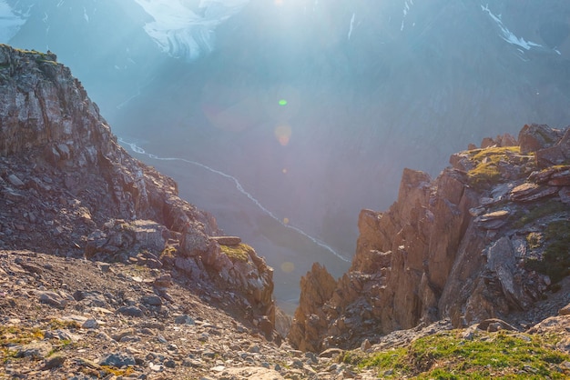 Sonniger Blick auf die Berge von der Klippe in sehr großer Höhe Malerische alpine Landschaft mit schönen scharfen Felsen und Couloirs und großem Gletscher im Sonnenlicht Schöne Landschaft am Rand des Abgrunds mit scharfen Steinen