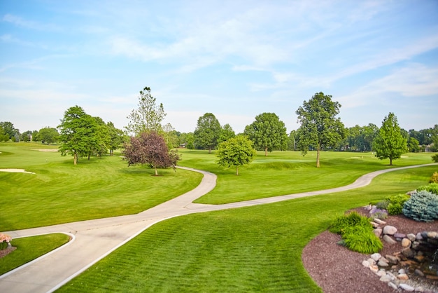 Sonniger Golfplatz mit vielfältigem Laub und eleganter Landschaft