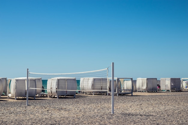 Sonniges Wetter am Strand, Meerblick, Sandstrand mit Volleyballfeld, Sommerurlaub im Resort