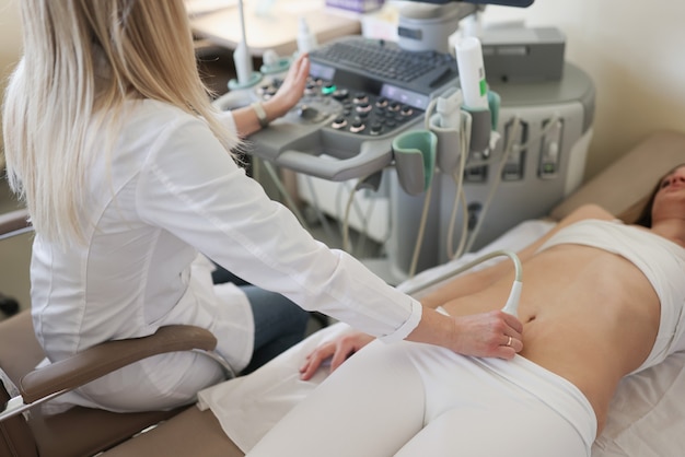 Sonographerhand untersucht Frau mit Ultraschallgerät