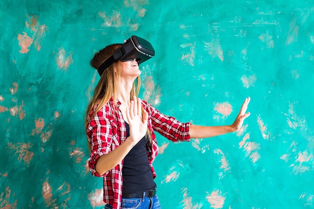 Sonríe a la mujer feliz obteniendo experiencia usando gafas de realidad virtual en casa con muchas manos gesticulantes.