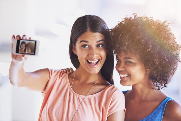 Sonríe a la pantalla del teléfono y a los amigos con una selfie de la ciudad para la diversión del viaje o la unión con el recuerdo de las vacaciones al aire libre Fotografía de teléfonos inteligentes o mujeres en la acera para la aventura de las redes sociales o la imagen de perfil