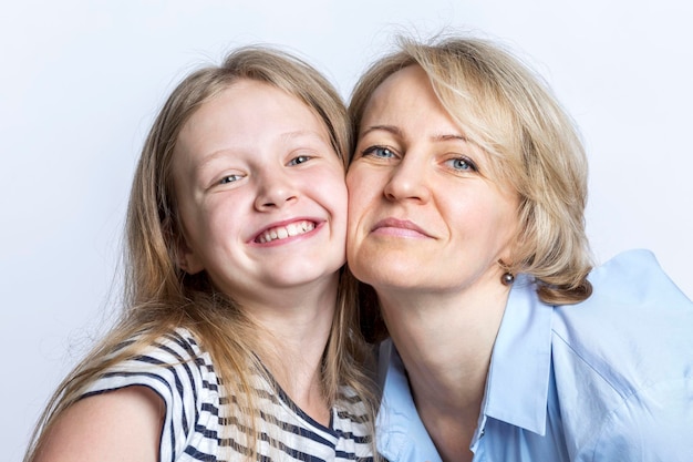 Sonriendo y abrazando a madre e hija Amor y ternura Primer plano Fondo blanco