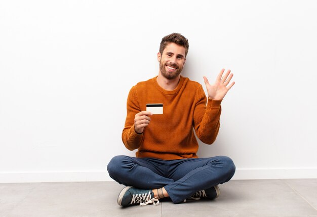 Sonriendo alegre y alegremente, saludando con la mano, dándole la bienvenida y saludándolo, o diciéndole adiós