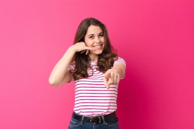 sonriendo alegremente y apuntando al frente mientras te llamo para luego gesticular, hablar por teléfono