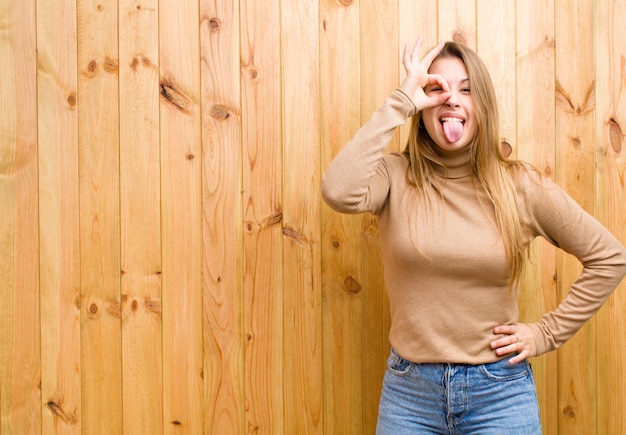 sonriendo alegremente con cara divertida, bromeando y mirando por la mirilla, espiando secretos