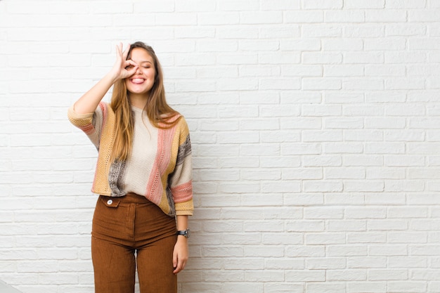 sonriendo alegremente con cara divertida, bromeando y mirando por la mirilla, espiando secretos