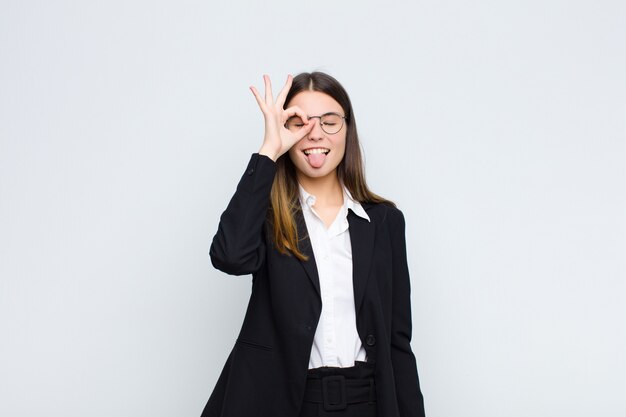 Foto sonriendo alegremente con cara divertida, bromeando y mirando a través de la mirilla, espiando secretos