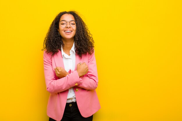 sonriendo alegremente y celebrando, con los puños cerrados y los brazos cruzados, sintiéndose feliz y positivo