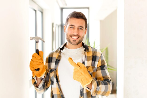 sonriendo alegremente, el hombre se siente feliz y apunta hacia un lado y hacia arriba, mostrando el objeto en el espacio de la copia