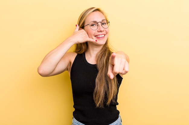 Sonriendo alegremente y señalando a la cámara mientras hace una llamada, luego gesticula hablando por teléfono